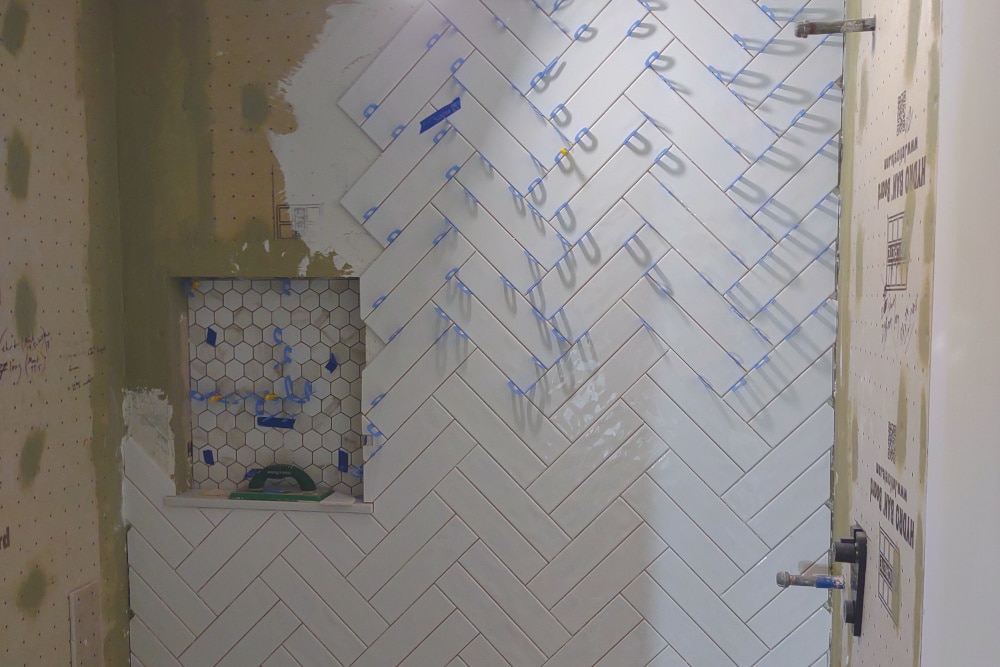 Double Herringbone Tile Installation on 
a shower wall with niche